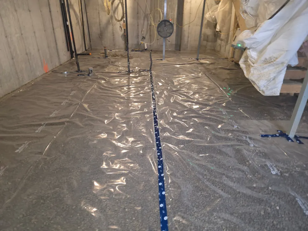 Basement floor vapor barrier and plumbing prep before concrete pour