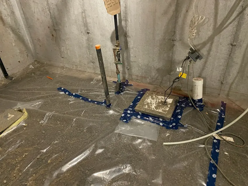 Basement plumbing rough-in and vapor barrier prep before pour